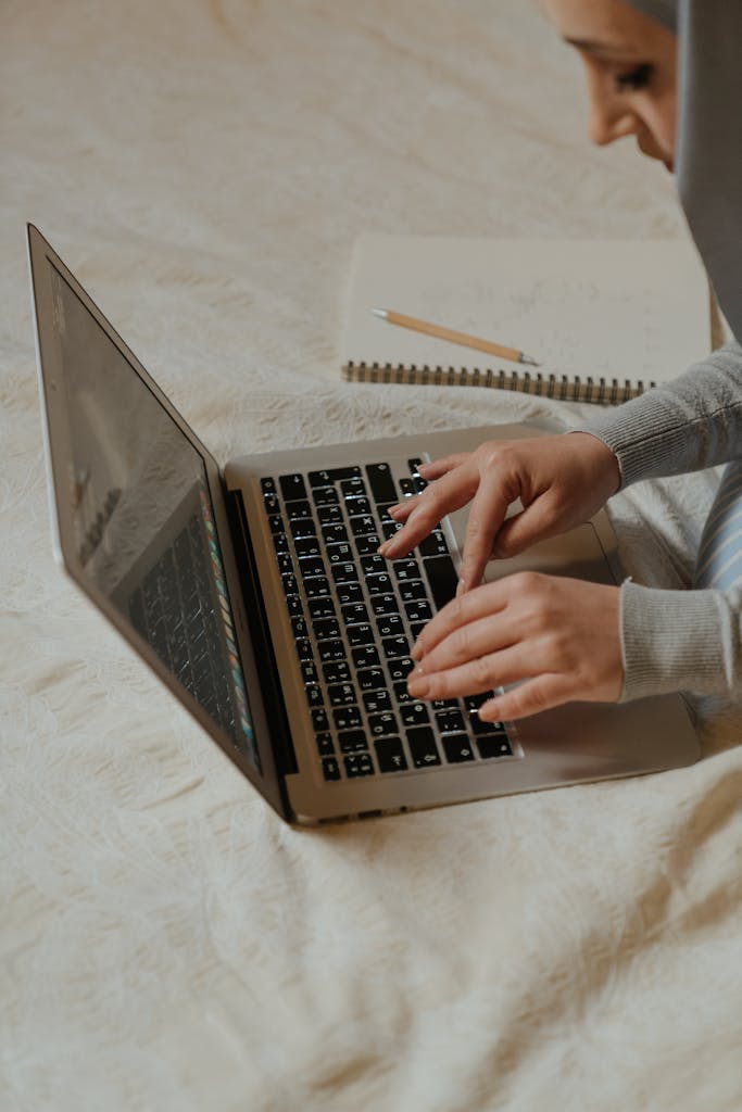 Person in Gray Long Sleeve Shirt Using Macbook Pro